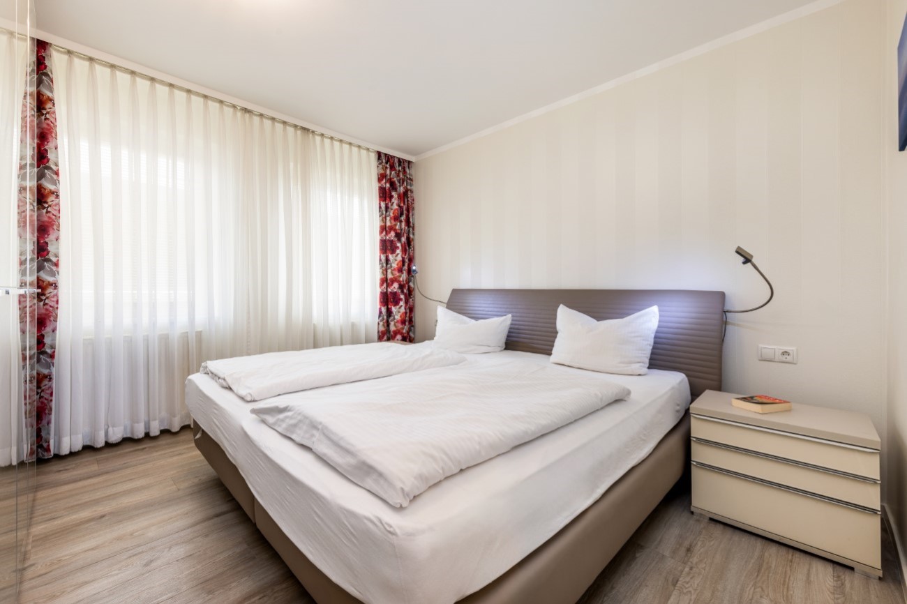 Aparthotel Ostsee in Binz auf der Insel Rügen - Ferienwohnung Meeresfreude - Schlafzimmer mit großem Doppelbett